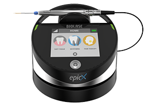 The image shows a portable dental device with a digital display, a toothbrush head, and various buttons, indicating its use for oral health care.