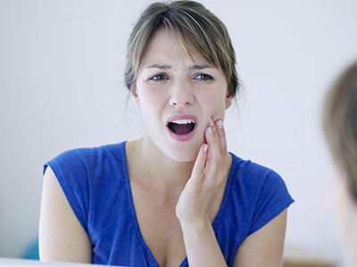 The image shows a woman with her mouth open, displaying concern or surprise, looking directly at the camera.