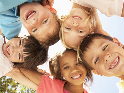 A group of children, each with a unique smile and pose, gathered together in a joyful display of unity and friendship.